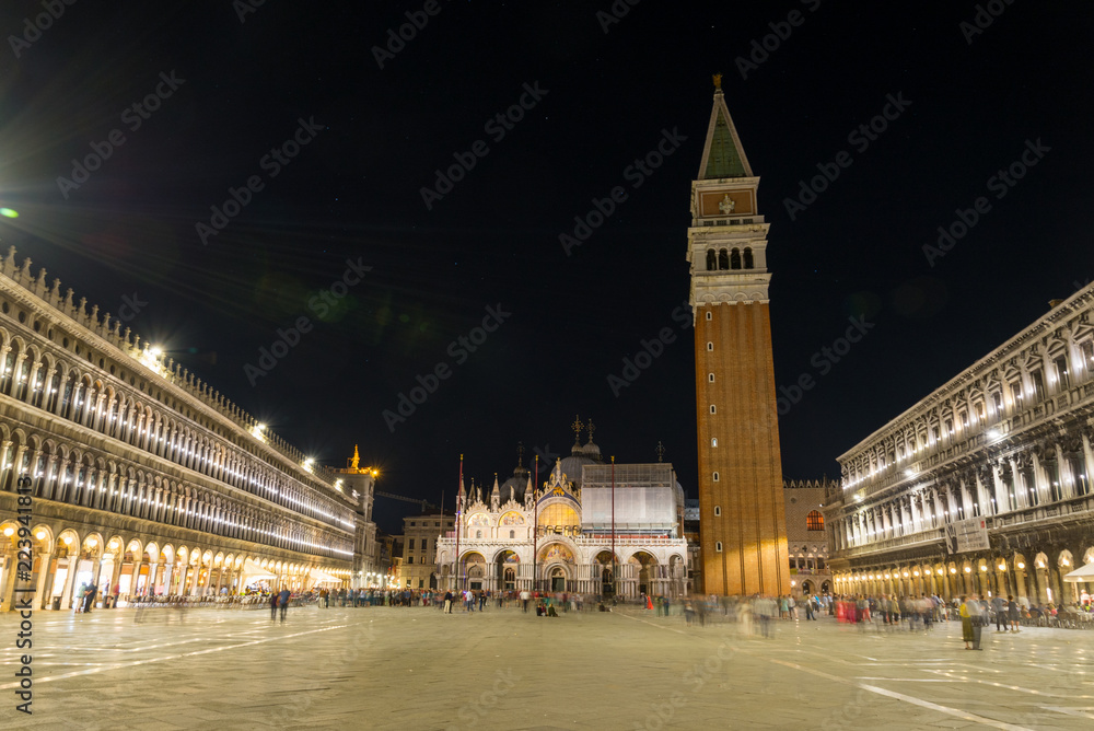 Night scenery of Piazza San Marco, St. Mark's Square, the square surrounded by shop, restaurant, Saint Mark's Basilica and St Mark's Campanile in Venice, Italy.