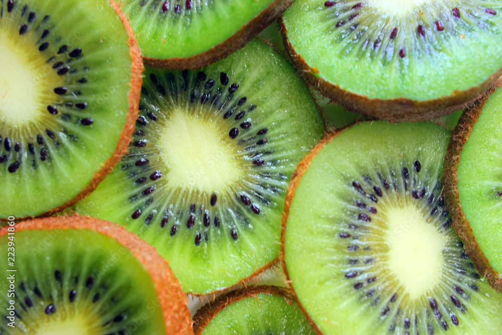 Kiwi fruit cut into pieces against a light background, close-up