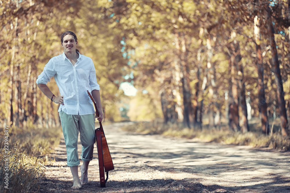 Obraz premium Autumn rainy weather and a young man with an umbrella