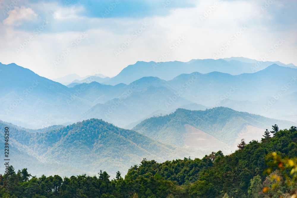 Mystical landscape of misty layers of mountains  with sunrays