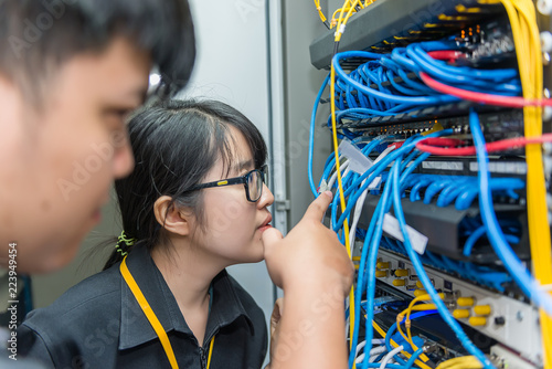 Two asian engineers working in the server room,Check the connection problems of computer networks,Thailand people