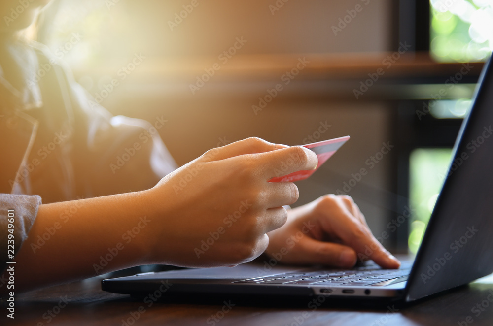 Online payment,woman's hands holding credit card and using laptop computer for online shopping. Cyber Monday Concept