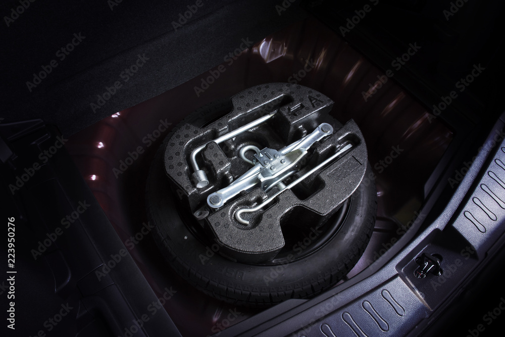 Φωτογραφία Car jack and wheel changing tool kit in spare tyre of car, automotive part concept