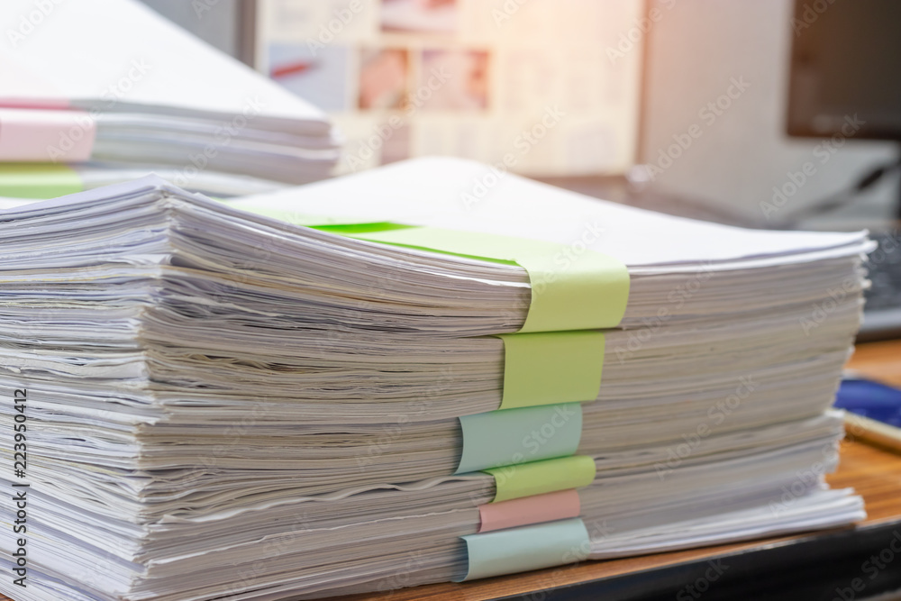 Close up pile of unfinished homework assignment stacked in archive with colorful papers on teacher's table waiting to be managed and inspected. Stack of paperwork. Education and business concept. Close up pile of unfinished homework assignment stacked in archive with colorful papers on teacher's table waiting to be managed and inspected. Stack of paperwork. Education and business concept.
