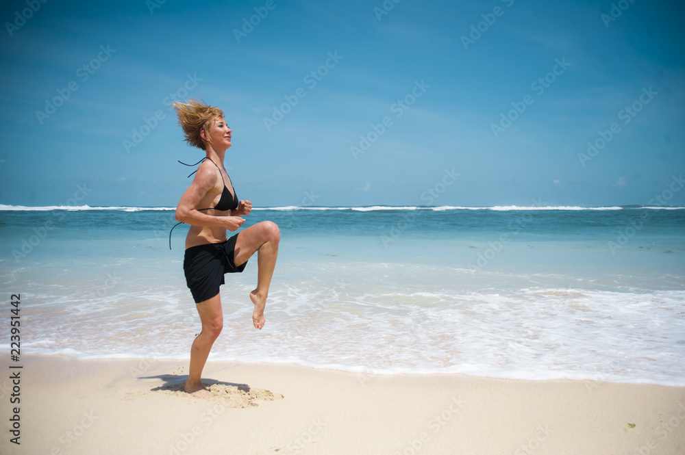 young happy and attractive sporty woman doing fitness skipping cardio exercise on tropical paradise beach enjoying summer cardio workout isolated on beautiful sea young happy and attractive sporty woman doing fitness skipping cardio exercise on tropical paradise beach enjoying summer cardio workout isolated on beautiful sea
