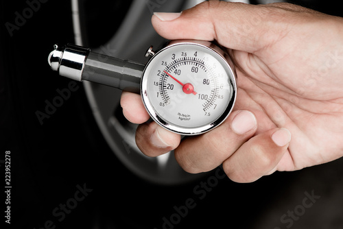 Hand of man holding gauge measurement pressure checking tire of car transportation
