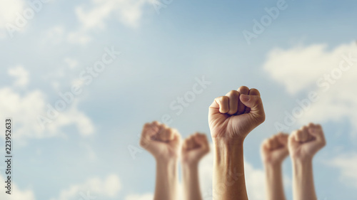 Peoples raised fist air fighting and sunlight effect, Competition, teamwork concept, background space for text. photo