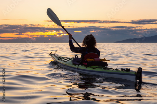 Girl Sea Kayaking during a vibrant sunny summer sunset. Taken in Vancouver, BC, Canada.