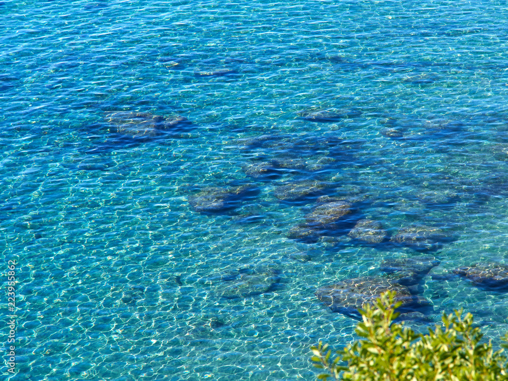 Fototapeta premium Clear blue sea ocean water over rocks