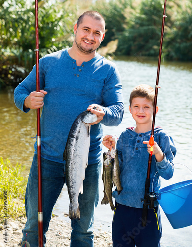 Portrait of father and son fishing with rods