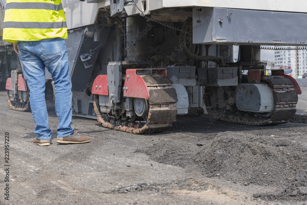 Close view on the workers and the asphalting machines. Machinery for asphalting roads Close view on the workers and the asphalting machines. Machinery for asphalting roads