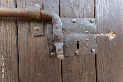 Portone in legno con chiavistello a scorrimento in ferro, catenaccio chiuso photo