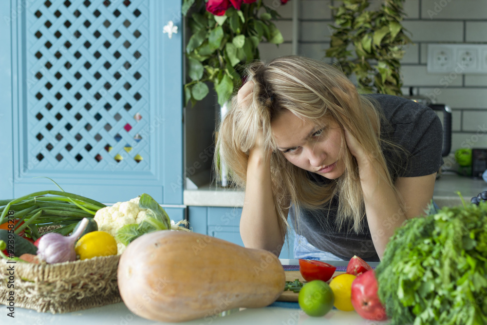 The girl is tired in the kitchen .Mistress. Vegetarian cuisine. A young European in his twenties.The concept of healthy eating. The girl is tired in the kitchen .Mistress. Vegetarian cuisine. A young European in his twenties.The concept of healthy eating.
