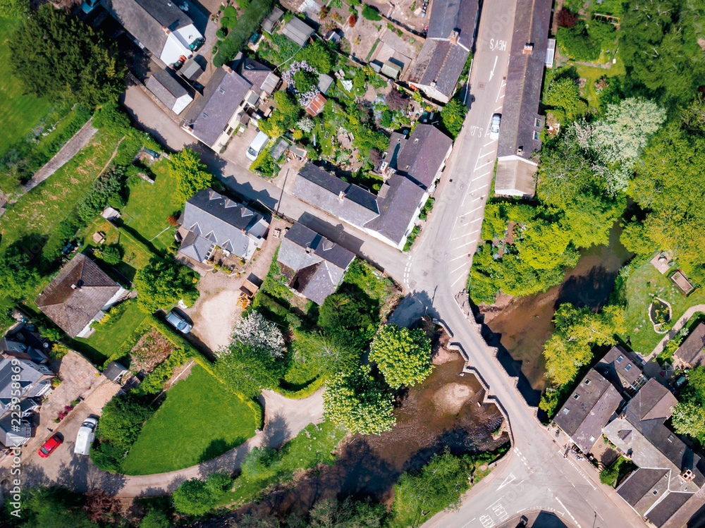 Aerial view above houses in an old British village in the countryside. Warm colours give a homely effect. Aerial view above houses in an old British village in the countryside. Warm colours give a homely effect.