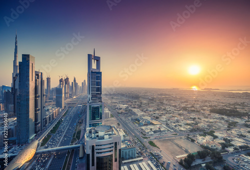 Skyscrapers and highways of a big modern city at sunset. Aerial view on downtown Dubai, United Arab Emirates. Colourful skyline.