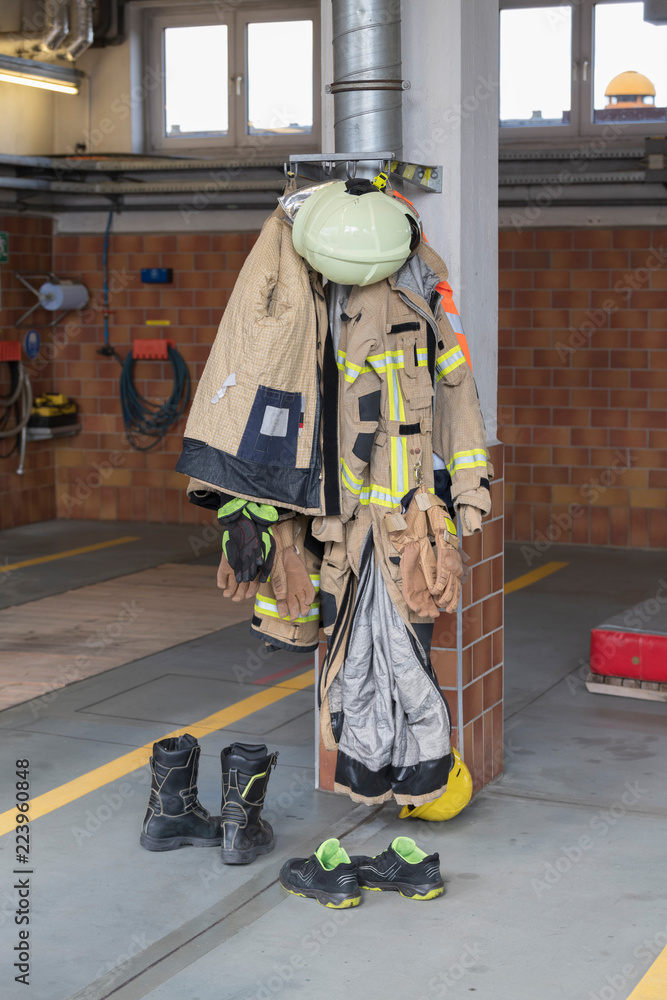 Bekleidung eines Feuerwehrmanns hängt an einem Pfeiler