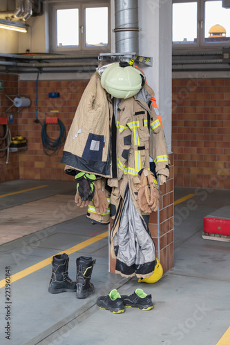 Bekleidung eines Feuerwehrmanns hängt an einem Pfeiler  