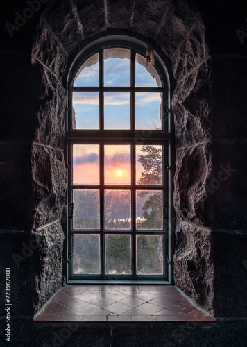 Cosy view looking through an old window with sunset at autumn morning in National Park, Finland