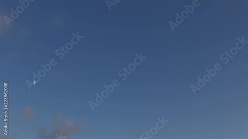 timelapse of clouds crossing the amazing sky at sunset. The clouds cross slowly from right to left and appear to be orange blue and purple. the clouds are grey, purple, yellow and red