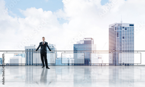 Sunrise above skyscrapers and businessman facing new day