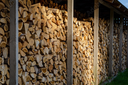 Wooden background. Firewood drying for the winter, stacks of firewood