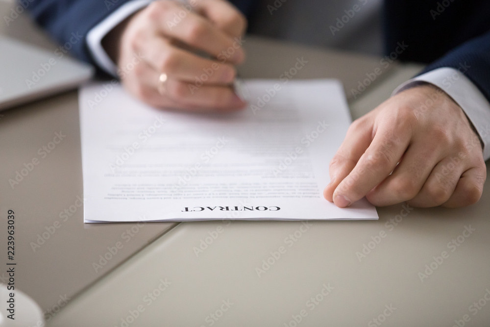 Obraz premium Close up of male worker or manager put signature on work contract making agreement, businessman or CEO sign document closing business deal with partner after successful meeting. Cooperation concept