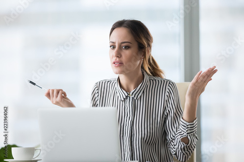 Confused businesswoman feel at loss looking at laptop screen with error message, frustrated female worker shocked by computer malfunction or online problem, seeing notice about pc crash or bad news