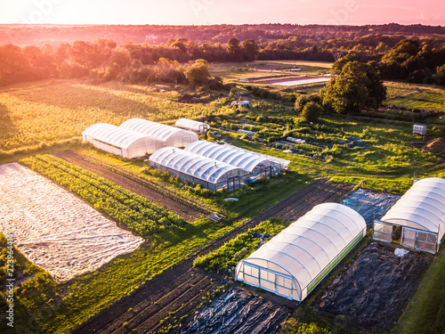 Drone aerial photography of an organic inner city farm taken at sun set in London. Polytunnels, agricultural buildings and farmland taken on the outskirts of a city. photo