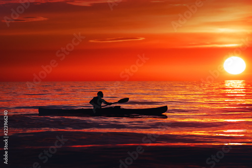 Silhouette of a man and canoe at a colorful summer ocean sunset: paddling is a perfect activity at the beach. Lønstrup in North Jutland in Denmark, Skagerrak, North Sea