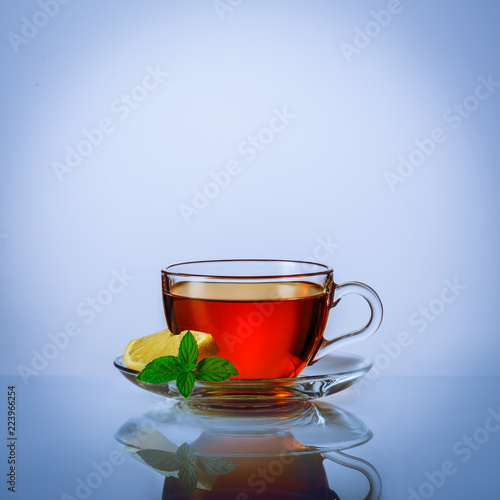 Black tea in the glass cup with lemon and mint.