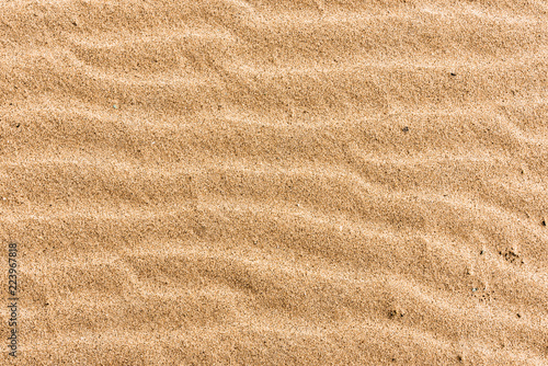 Beach sand with stripes from the waves - natural background with copy space