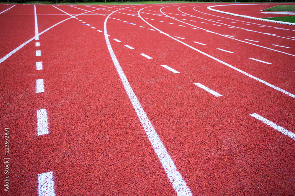 Fototapeta premium red rubber running racetrack with white lines in outdoor stadium