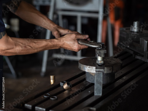 Men's hands with locking pliers Working on Lathe machine. metalworking industry concept.