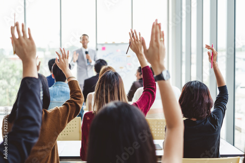 Fotografi Group of business people raise hands up to agree with speaker in the meeting roo