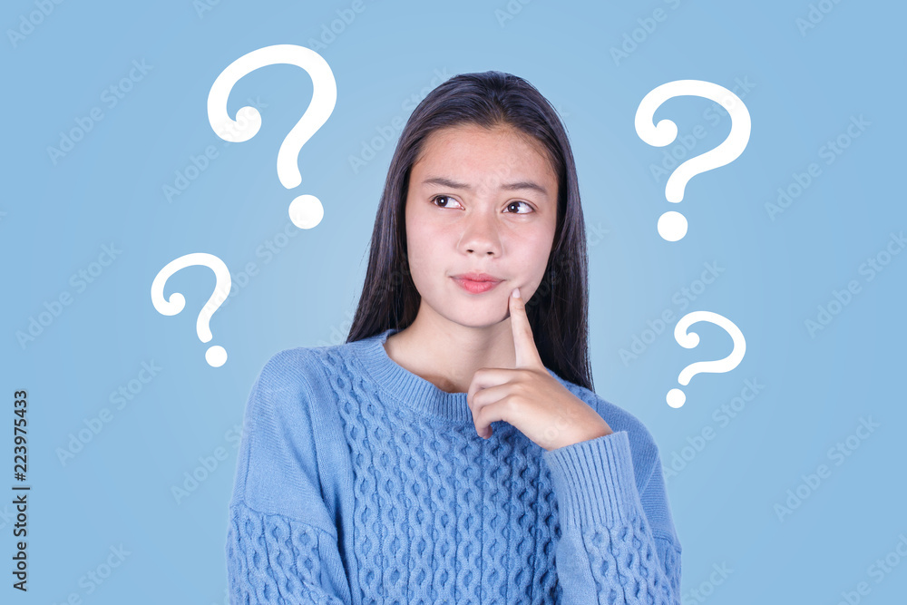 Asian young girl with question marks on blue background Asian young girl with question marks on blue background