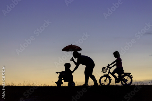 mother and dauhhter ride bicycleThe silhouette photo of mother and her daughter riding bicycle in the park with sweet sky at sunset.