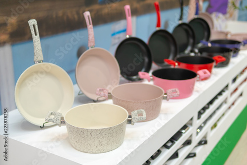 Frying pans and kitchen pans on the shelf in the store.