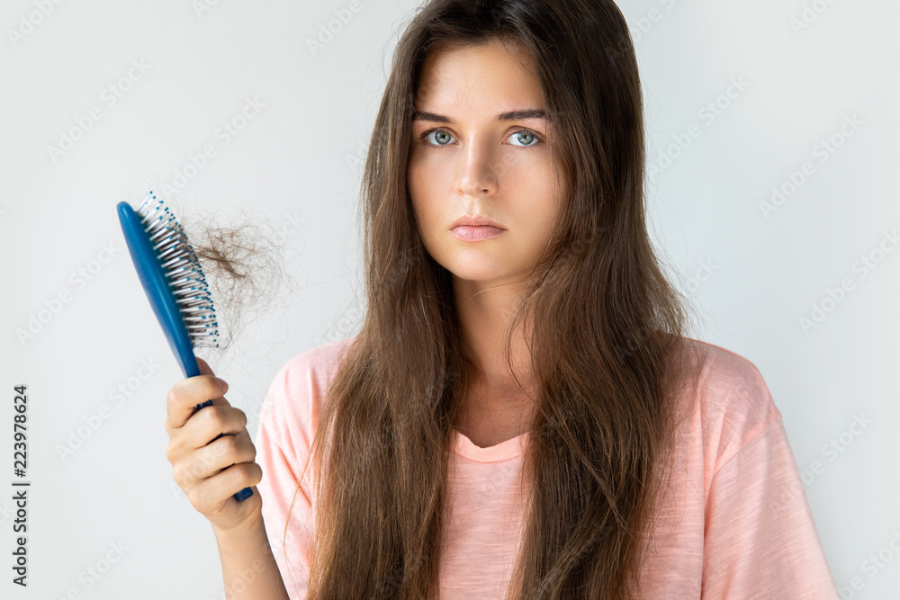 Young woman is upset because of hair loss Young woman is upset because of hair loss
