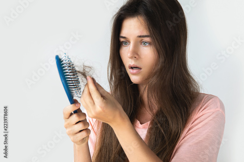 Young woman is upset because of hair loss photo