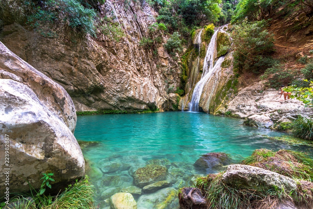 Natural waterfall and lake in Polilimnio area in Greece. Polimnio is a complex of waterfalls and lakes are located near Charavgi Municipality, Messinia prefecture, Peloponnese, Greece.