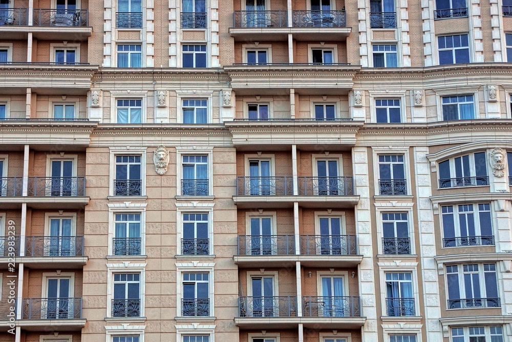 the texture of the multitude of windows and balconies on the brown wall of the building