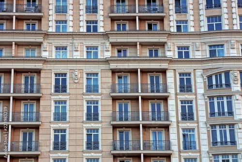 the texture of the multitude of windows and balconies on the brown wall of the building