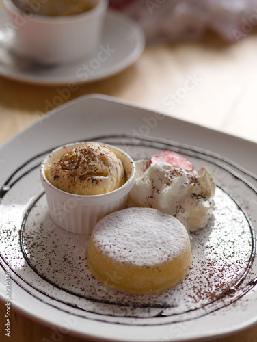Wallpaper Mural Yellow icecream with white cream and strawberry in white plate closeup. Torontodigital.ca