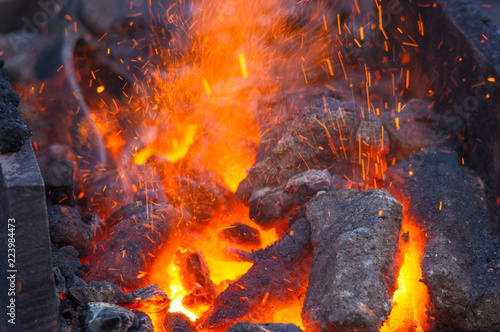 Photo blacksmith furnace with burning coals, tools, and glowing hot metal workpieces