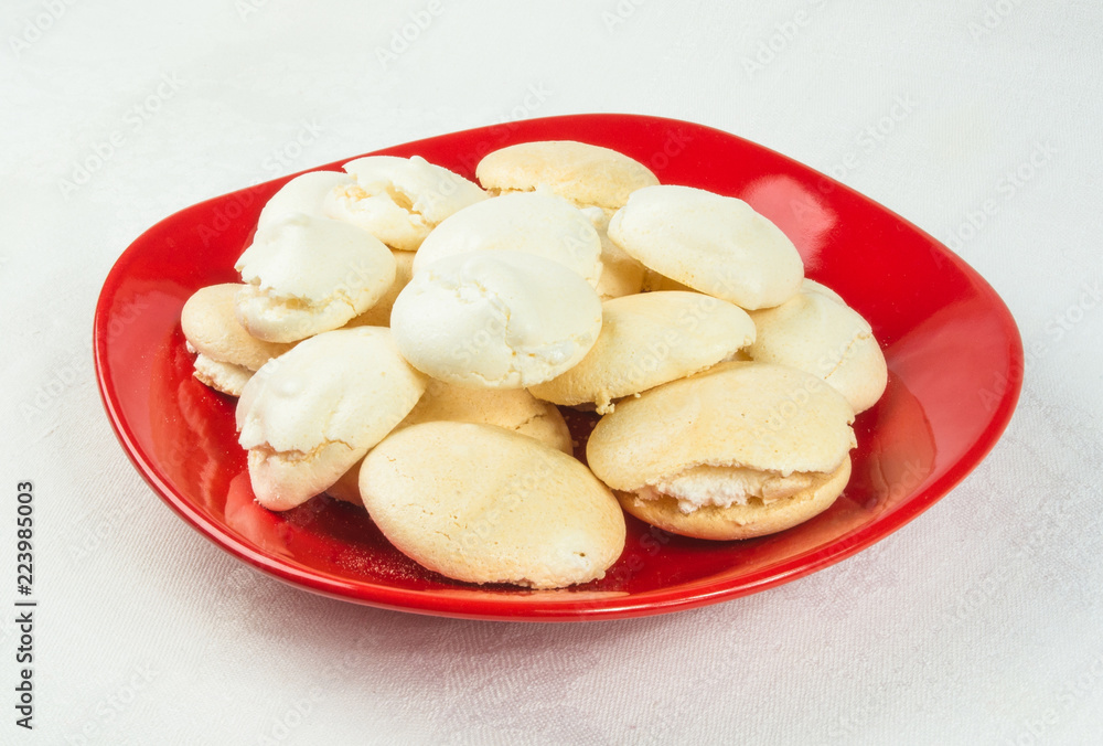 red plate with meringues on a white background