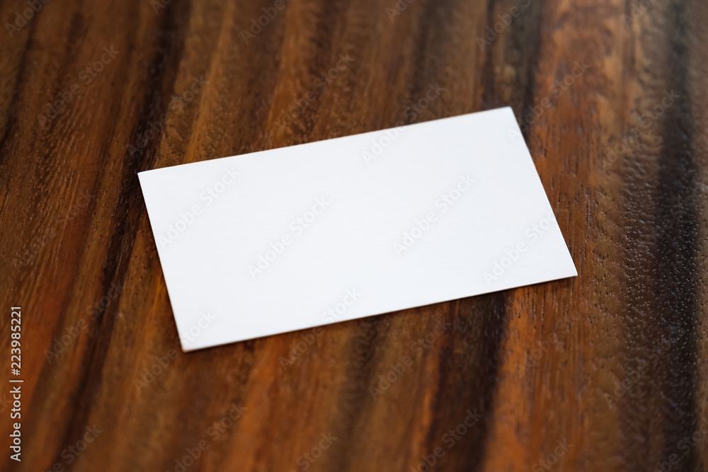 Top view image of a white blank business card on vintage wooden background Top view image of a white blank business card on vintage wooden background