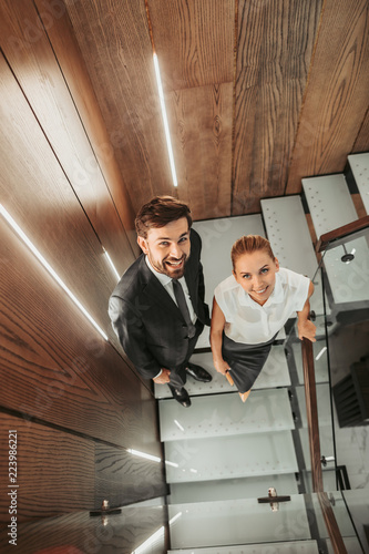 Top view portrait of optimistic bearded male worker standing near positive lady while communicating with her © Yakobchuk Olena