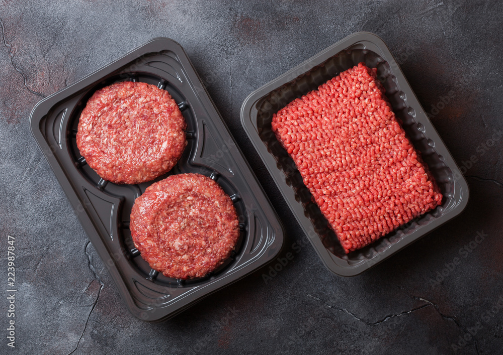 Plastic tray with raw minced homemade meat beef burgers with spices and herbs. Top view. Plastic tray with raw minced homemade meat beef burgers with spices and herbs. Top view.