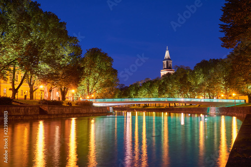  The night view of Aura river in Turku, Finland with a clock tower of cathedral and bridge on a background.                  