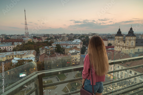 Woman looking into the city at sunset